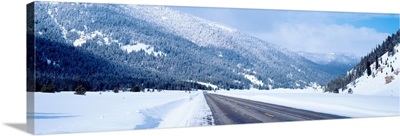 Road passing through a snow covered landscape, Yellowstone National Park, Wyoming