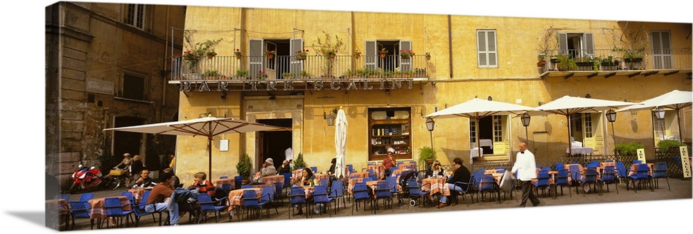Panoramic photo on canvas of people dining in an outside cafo area in Italy with old buildings in the background.
