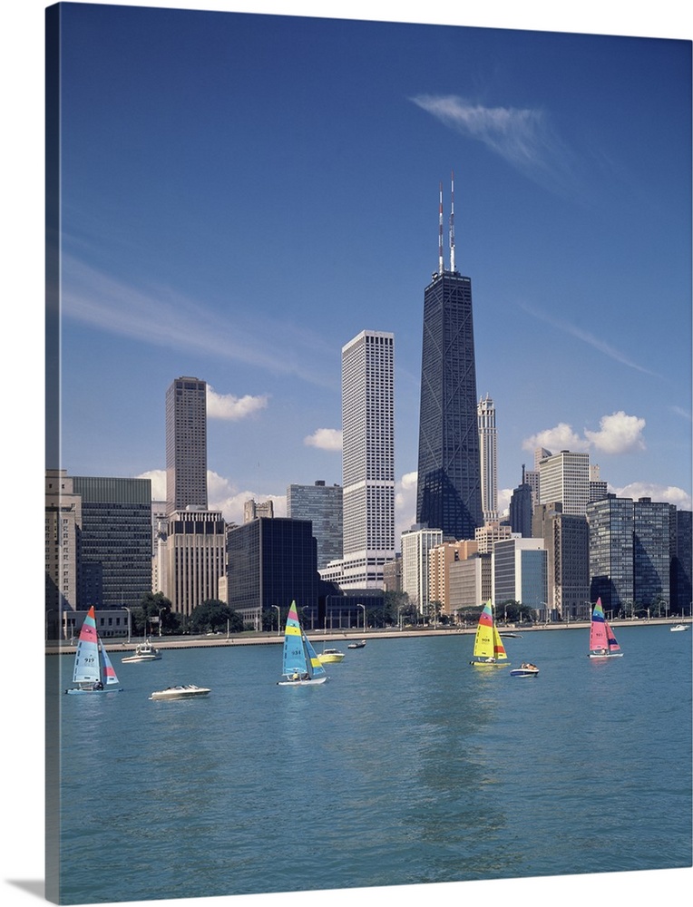 Vertical photograph of several boats on Lake Michigan in front of Chicago skyscrapers in Illinois.