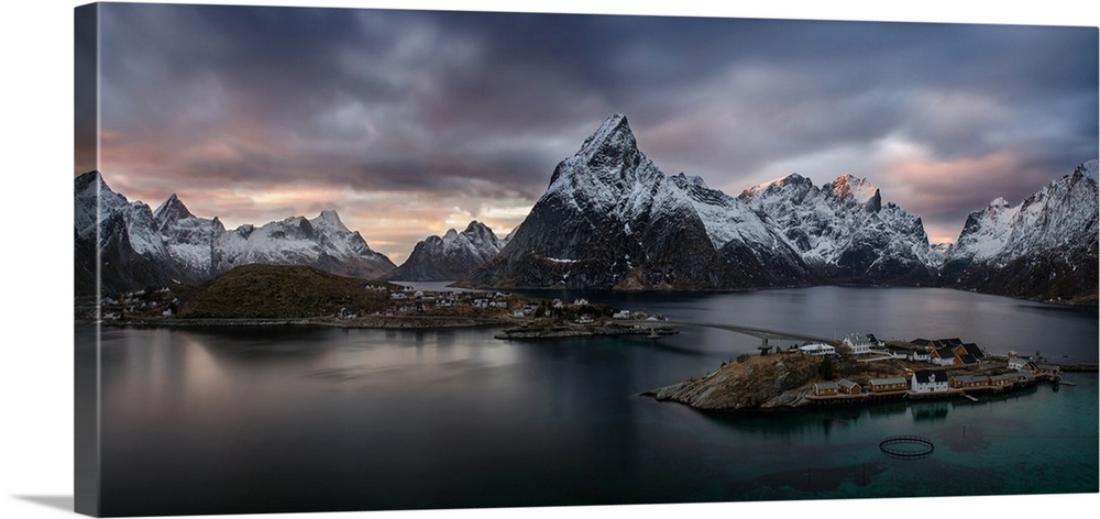 Sakrisoya village on Reinefjorden among snowy mountains at sunset, Lofoten, Nordland, Norway.