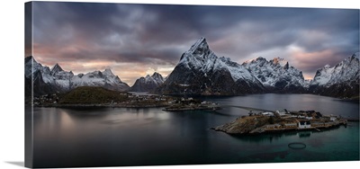 Sakrisoya village on Reinefjorden among snowy mountains at sunset, Norway