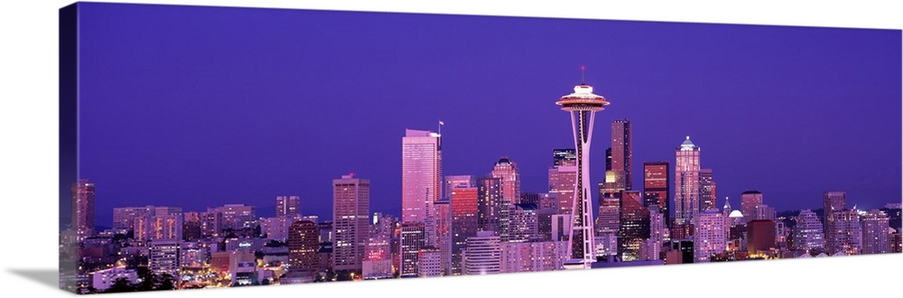 The Seattle skyline is illuminated under a dusk sky and photographed as a panorama.