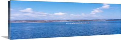 Side profile of a crew rowing on a lake