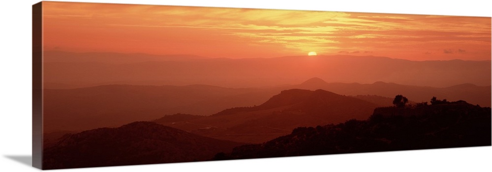 Giant panoramic photo on canvas of layers of Italian hills with a setting sun in the distance.