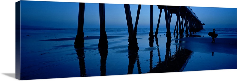 Big, landscape, panoramic photograph looking upward at an angle toward the Hermosa Beach Pier in California, at dusk. The ...