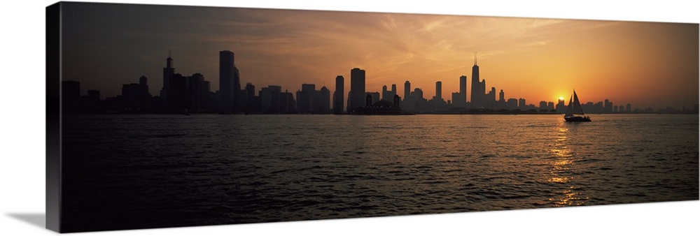 Panoramic photograph on a large canvas of a silhouetted Chicago skyline on the horizon of Lake Michigan, a sailboat floats...