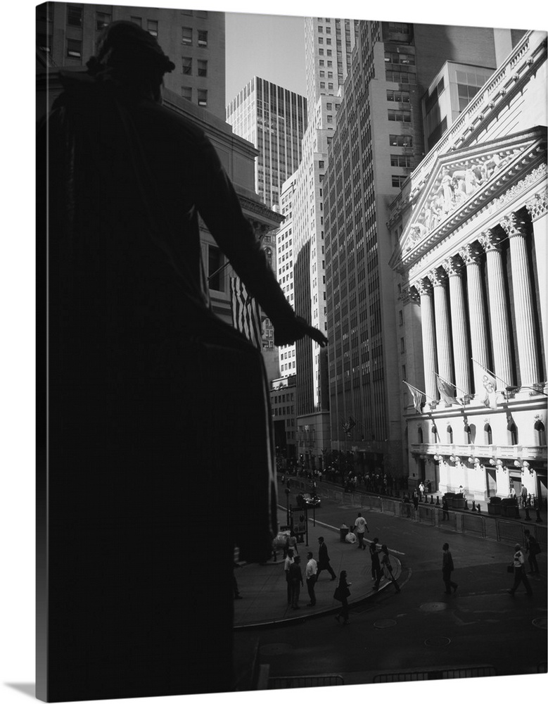Vertical photograph on a large wall hanging of a street view of New York City, including the New York Stock Exchange, Wall...