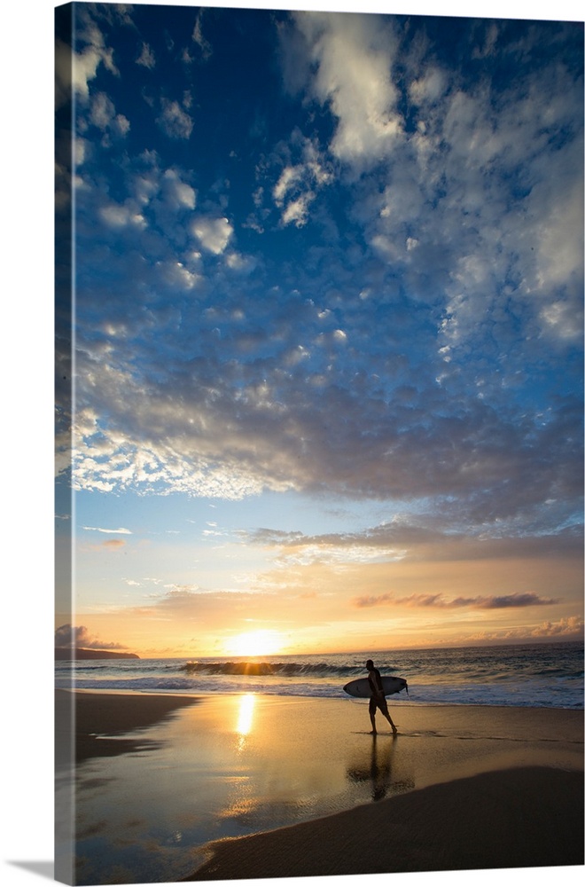 Silhouette of surfer walking on the beach at sunset, North Shore, Hawaii, USA