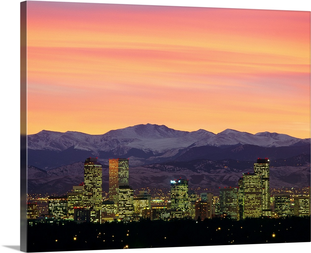 Large photograph taken of the Denver, Colorado skyline at dusk.  The snow covered mountains in the background provide a gr...