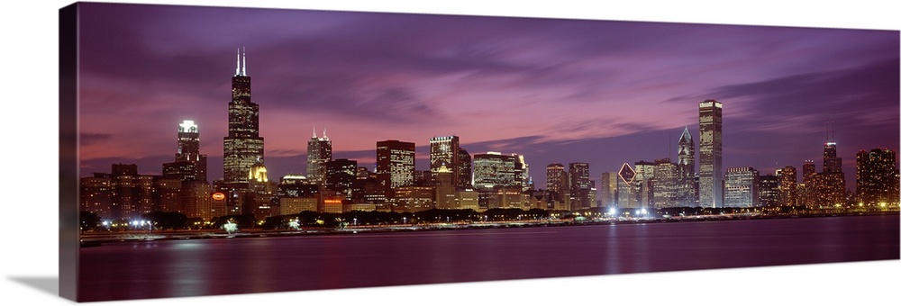 Panoramic photograph displays a horizon filled with tall skyscrapers and buildings at nighttime for the largest city in Il...