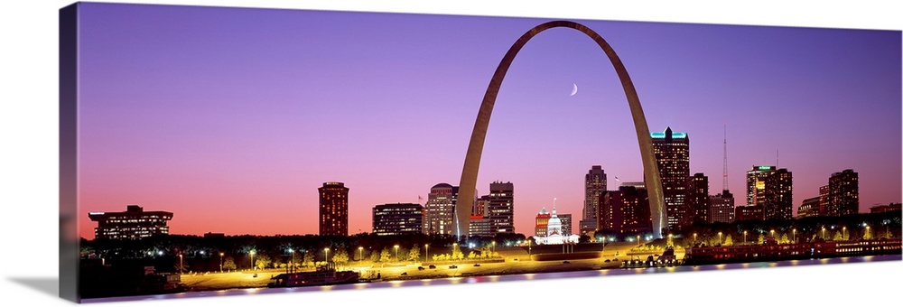 Panoramic photograph shows the skyline of St. Louis, Missouri reflecting into the Mississippi River within the foreground....