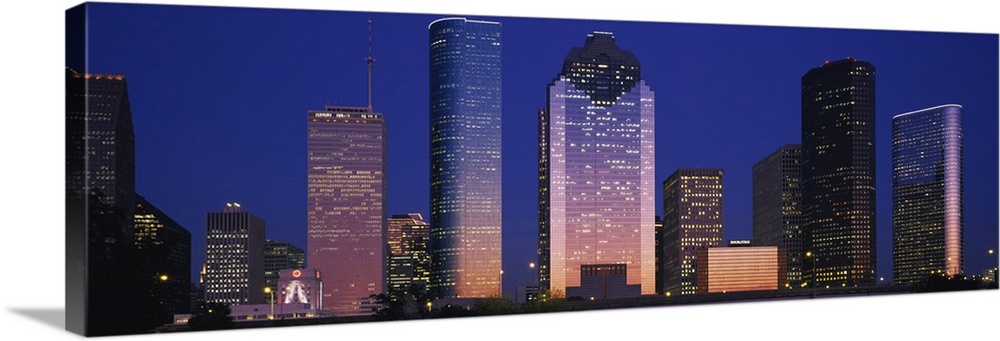Large panoramic view of the Houston skyline with the buildings illuminated during the night.