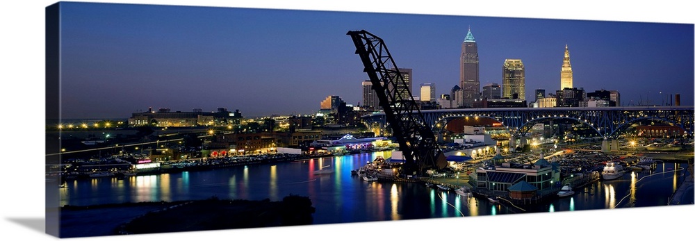 This is a panoramic photograph showing the downtown of the city and a river harbor with a raised railroad bridge.