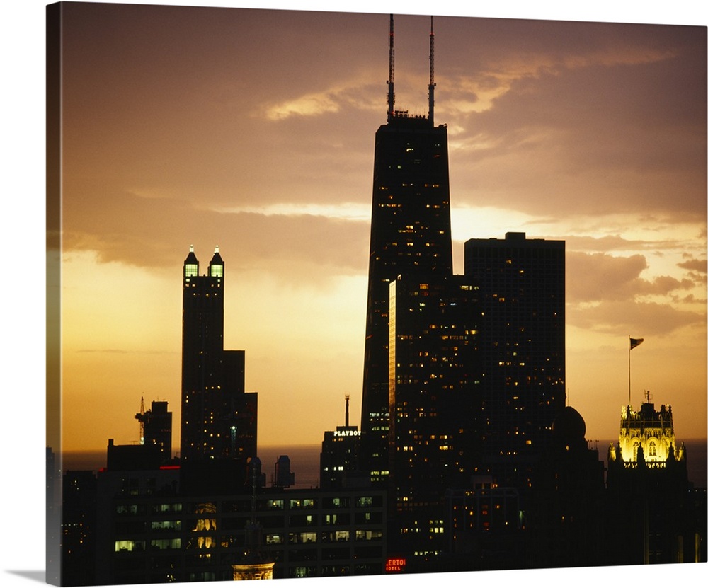Horizontal photograph on a big canvas of lit, tall buildings  of the Chicago skyline against the morning sky, at early sun...