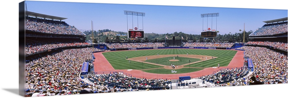 Panoramic photograph of inside baseball stadium with game in full swing.  The stands are packed with fans.