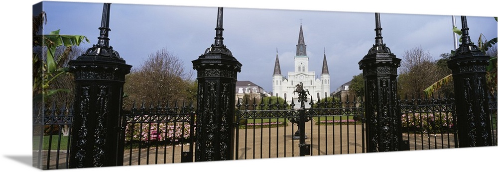 Panoramic photo on canvas of a big house of worship that is seen through iron fences located in Louisiana.