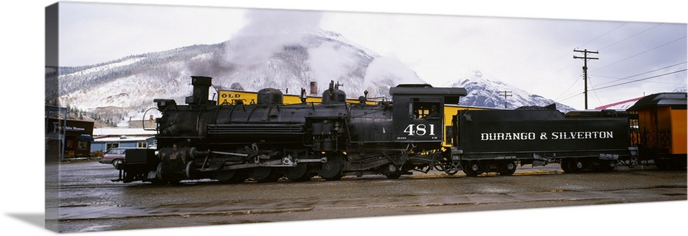 Oversized, horizontal photograph of a steam powered train and cars at the Durango and Silverton Narrow Gauge Railroad in C...