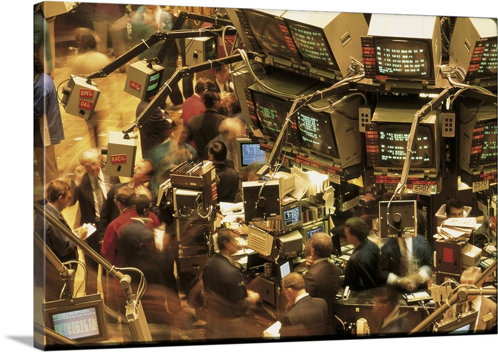 This is a retro photograph of the trading floor in New York from the 1980s where brokers are working in cluttered workspac...