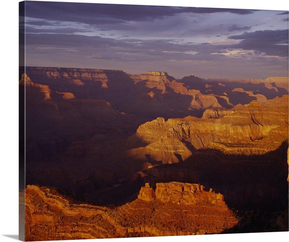 Vista of an arid desert canyon with strong shadows created by the late afternoon sun in the Southwest, with layers of rock...