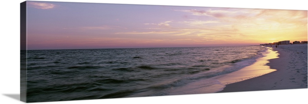 Panoramic picture taken from a beach in Florida with a sun kissed sky over the ocean.