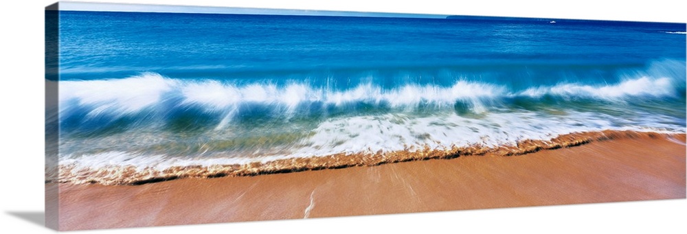 Giant, landscape photograph of a large wave crashing into the sands of Big Makena Beach in Maui, Hawaii.