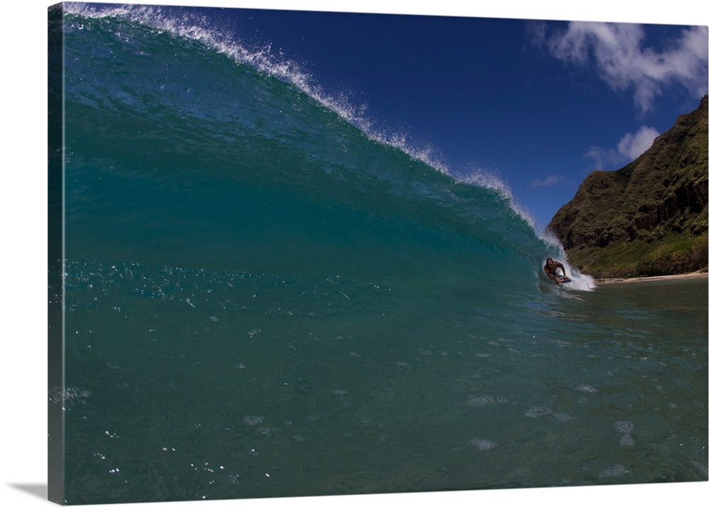 Surfer duck diving under a wave on beach, Hawaii, USA