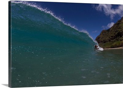 Surfer duck diving under a wave on beach, Hawaii