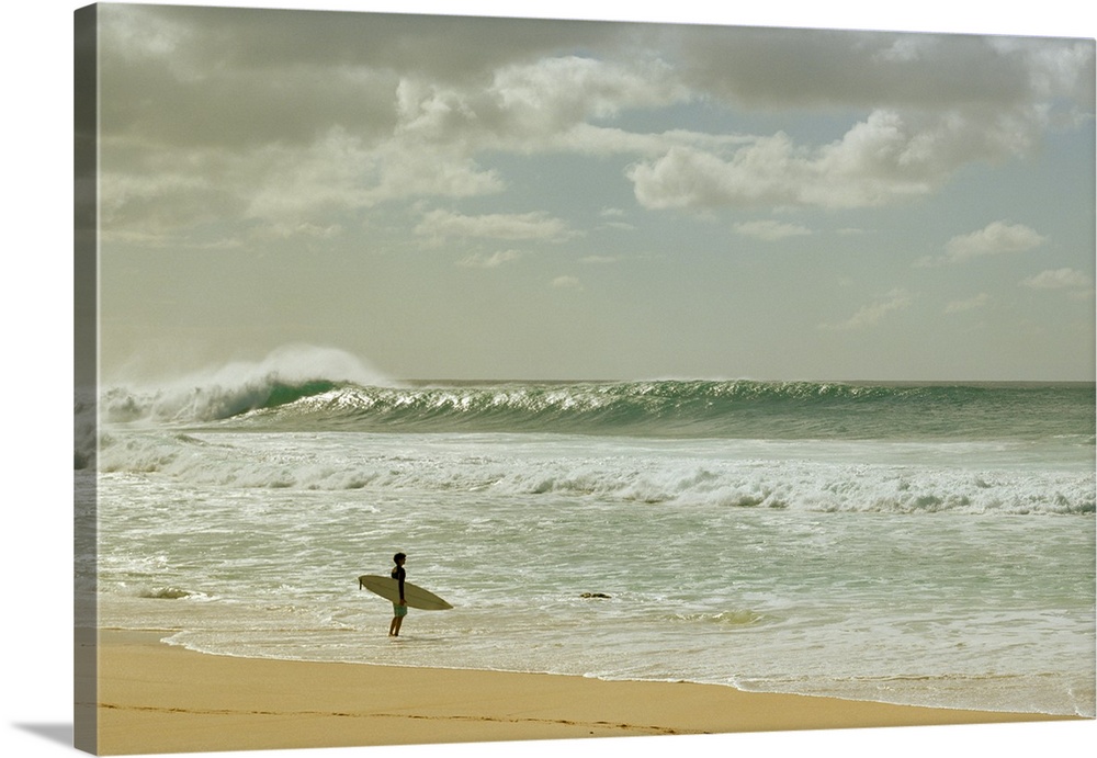 Surfer standing on the beach, North Shore, Oahu, Hawaii, USA