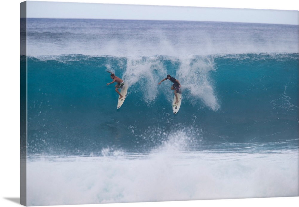 Surfers surfing down a wave on beach, Hawaii, USA