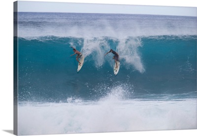 Surfers surfing down a wave on beach, Hawaii