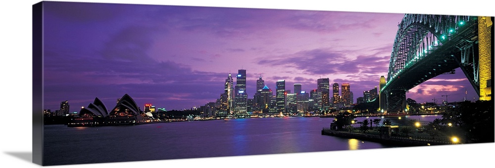 Panoramic photograph of the Sydney skyline with a structure just seen to the right of the picture and purple skies hoverin...