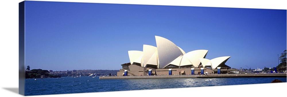 Panorama of the Sydney Opera House in front of a blue Australian sky.