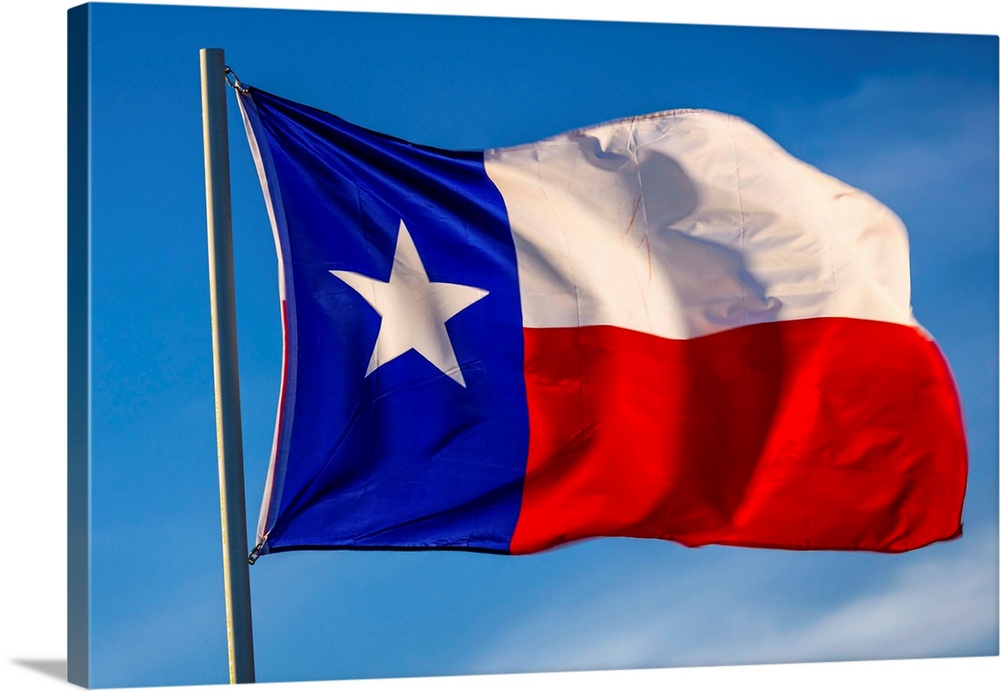 Texas "lone star" flag stands out against a cloudless blue sky, houston, texas.