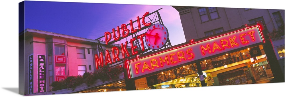 Big, landscape photograph, taken at and angle, of the neon Public Market sign in Seattle, Washington.  A neon farmers mark...