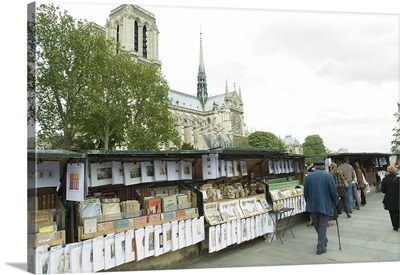 Tourists at the market stall with cathedral in the background, Notre Dame De Paris, Paris, Ile de France, France