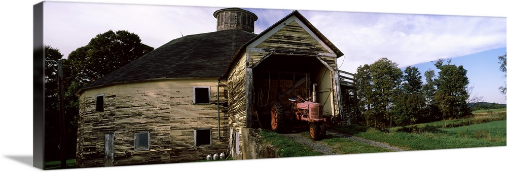Tractor parked inside of a round barn, Vermont,