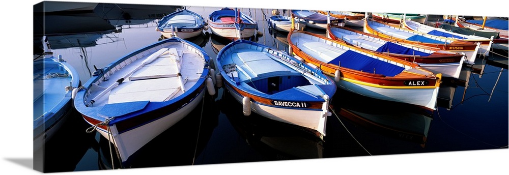 Panoramic photograph of colorful boats strung up in rows.