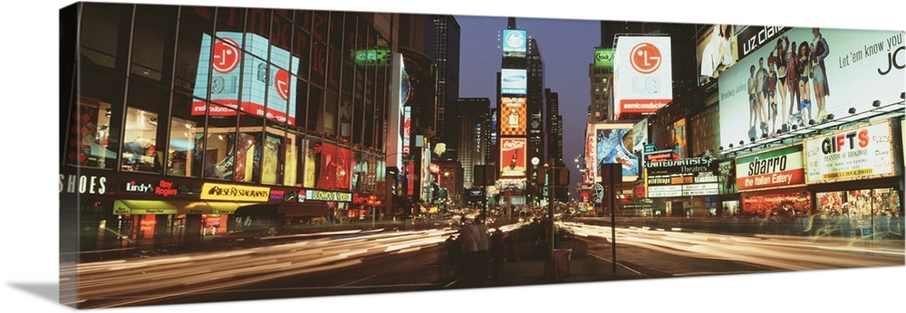 Giant landscape photograph of the lights of Times Square in downtown New York City at night, the street lit with light tra...