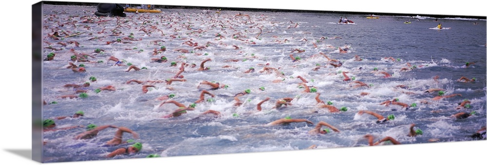 Sports action photograph of hundreds of swimmers racing in the Ironman in Kailua Kona, Hawaii.