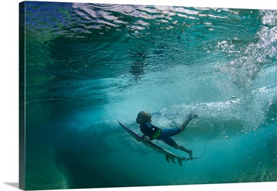 Underwater view of a surfer duck diving in ocean, Hawaii