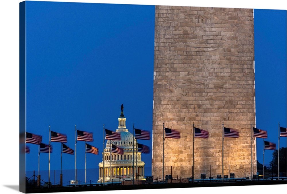 Us flags with cropped view of us capitol and washington monumentat night, washington, d.c.
