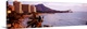 image thumbnail of A Hawaiian coast is photographed in wide angle view with a hotel sitting on the beach to the left and a large mountain sho...