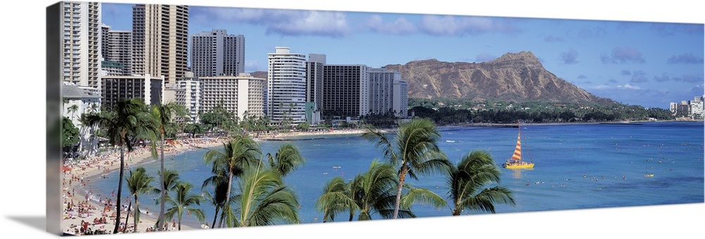 Large, panoramic photograph of tall buildings along the coast of Waikiki Beach in Honolulu, Hawaii.