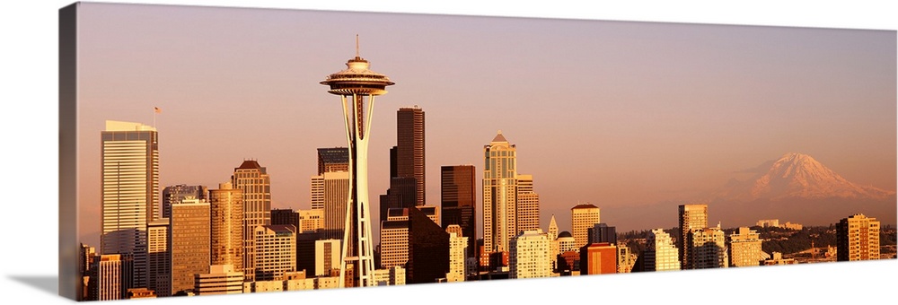 This panoramic photograph is the city skyline at sunset with Mount Rainer in the background.