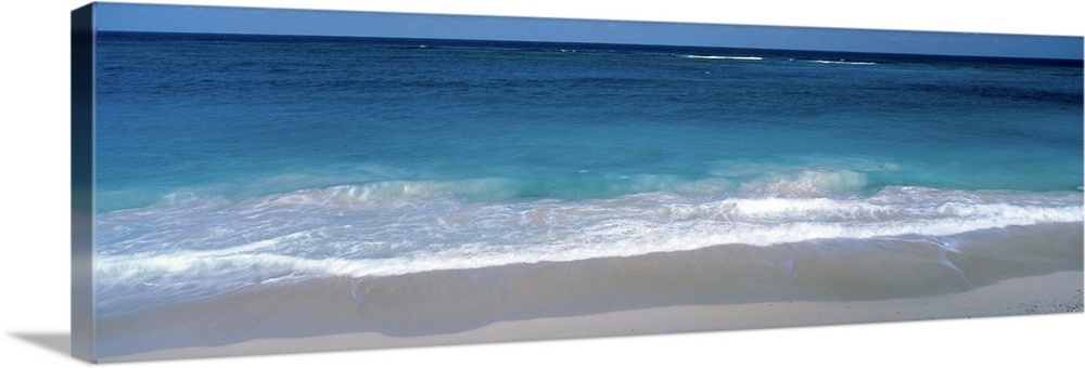 Panoramic picture of waves coming up on the white sandy beach in the Caribbean.