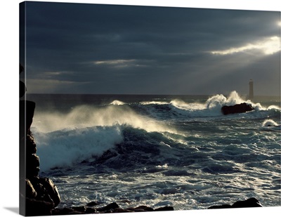 Waves breaking on coast with Nividic Lighthouse in the background, Ushant Island, France