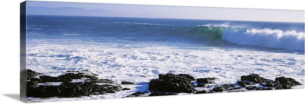 Long image on canvas of big waves crashing onto a rocky shore.