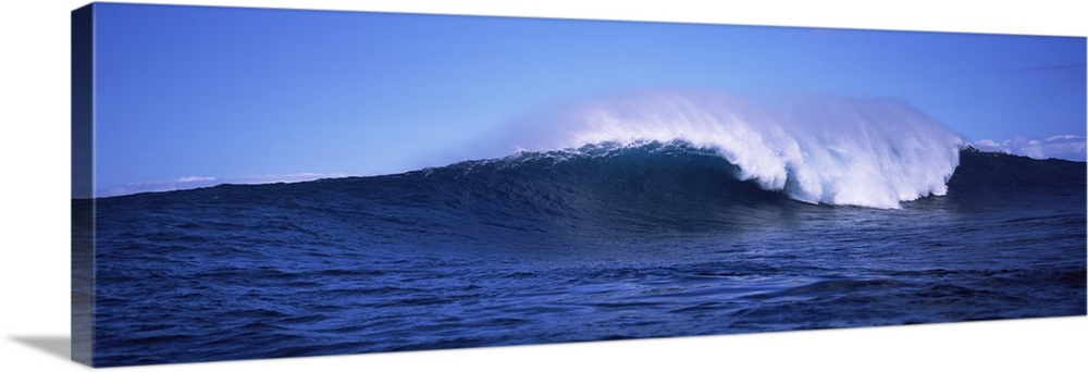 Long canvas photo of a big wave crashing in the ocean.