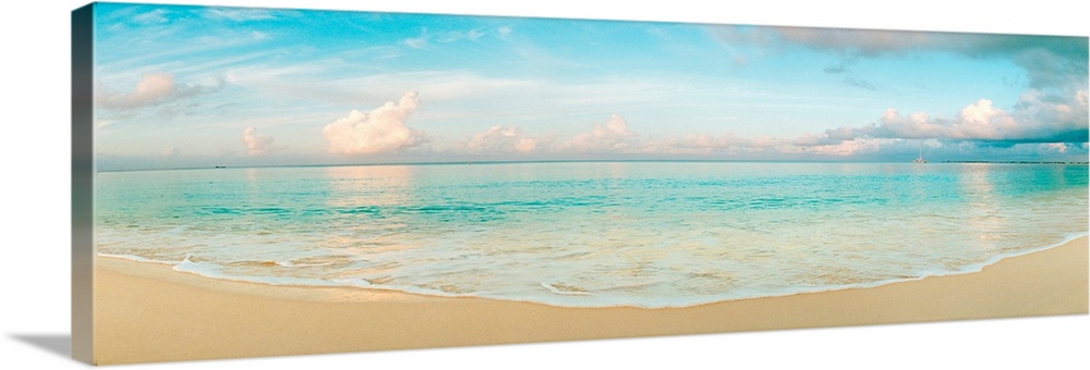 A wide angle panoramic wall hanging of a calm tropical ocean, waves on the beach, and cumulus clouds near the horizon.