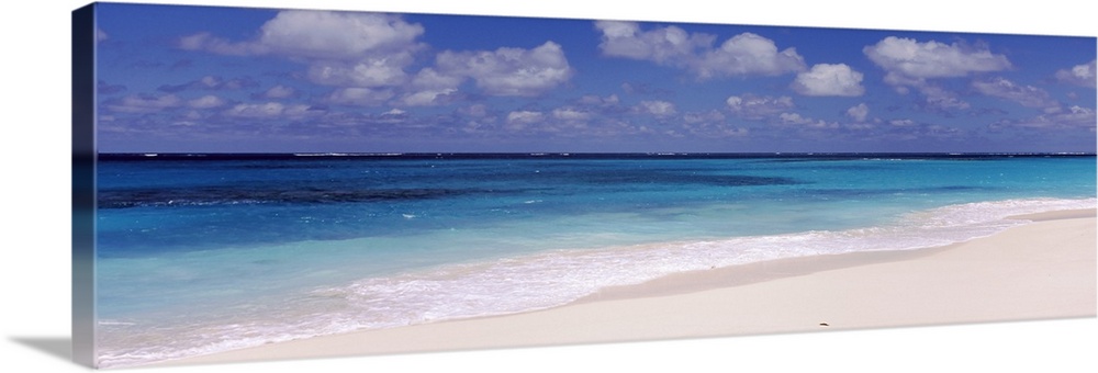 Panoramic photograph of the ocean against the sand on a cloudy day at Shoal Bay Beach in Anguilla.